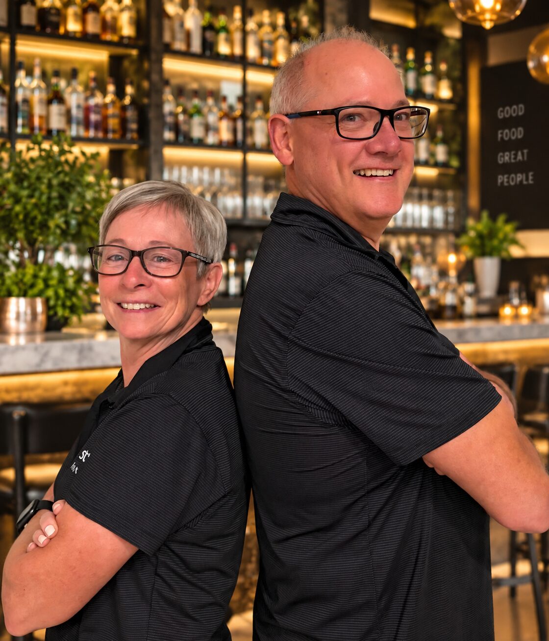 Brad and Helen standing back to back at a venue bar
